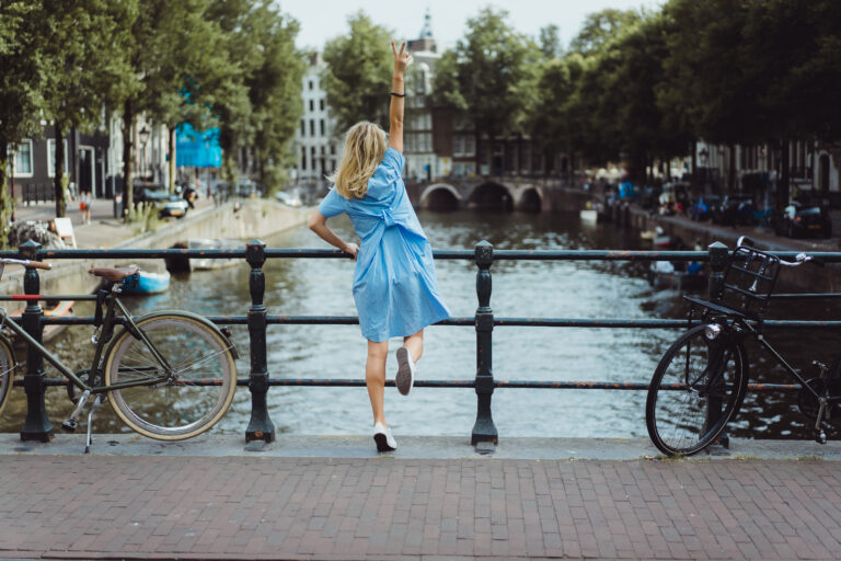 girl in a blue dress on the bridge in Amsterdam